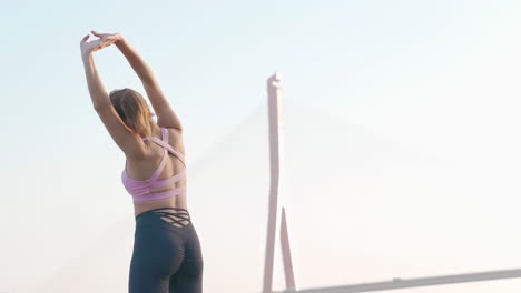 Attractive-athlete-woman-in-sportswear-doing-warm-up-exercise-before-running