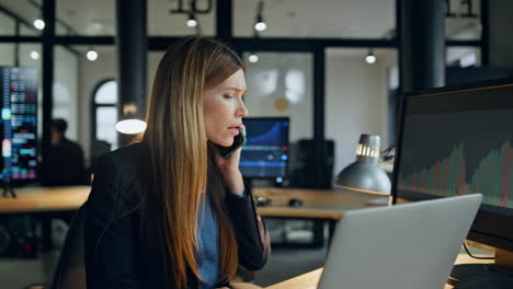 stressed broker talking mobile phone in office. upset woman get bad news on call