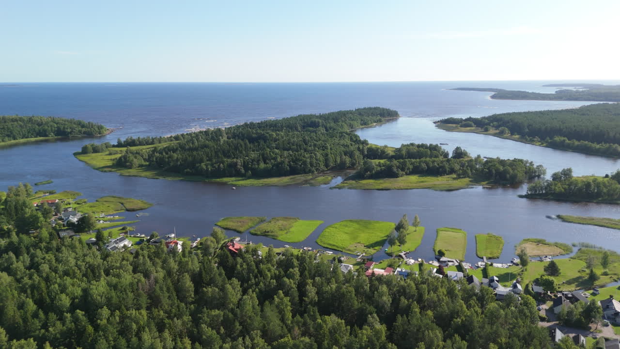 Houses line the Dalalven river where it meets the Baltic sea, tranquil aerial