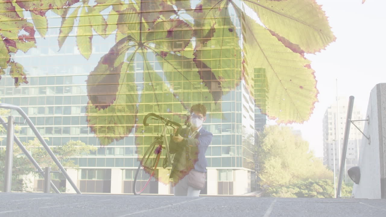 얼굴 마스크를 쓰고 자전거를 운반하는 아시아 남자의 잎의 애니메이션