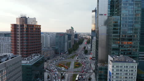Rising-footage-of-busy-wide-street-and-circuit-intersection-with-tram-tracks.-Tall-office-and-apartment-buildings.-Warsaw,-Poland