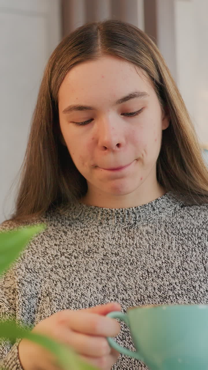 Serene morning ritual, Closeup of woman with reflective mood, Indoor scene of woman sipping tea calmly with plants, Serene woman in cozy sweater engaging in mindful tea drinking activity