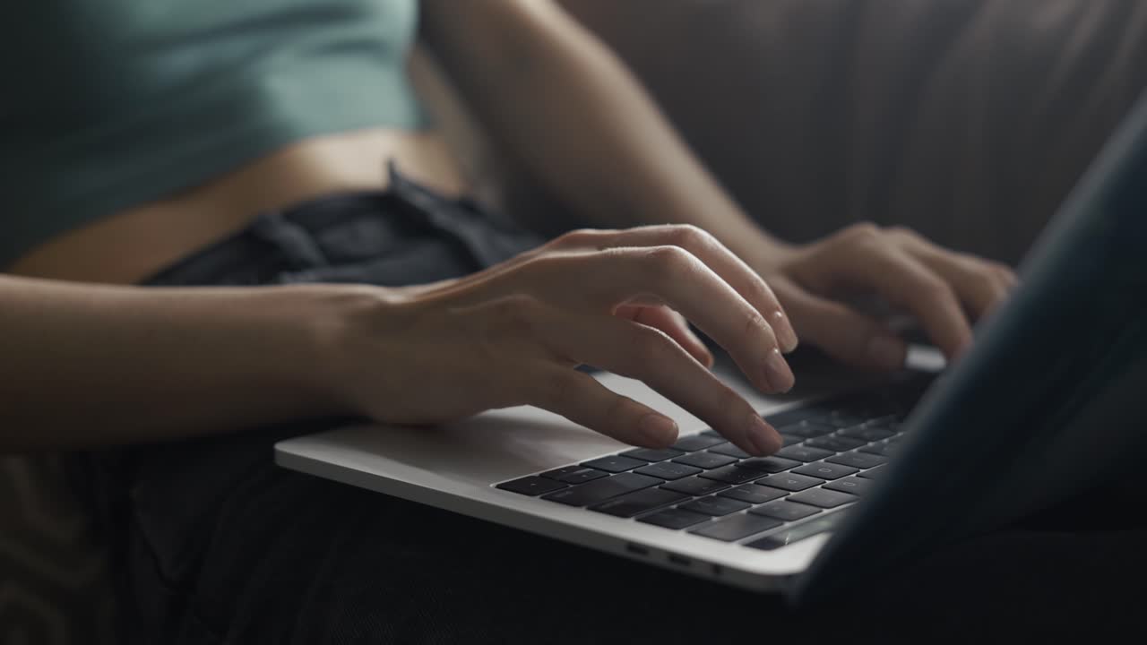 Close up of female's hands typing on laptop's keyboard