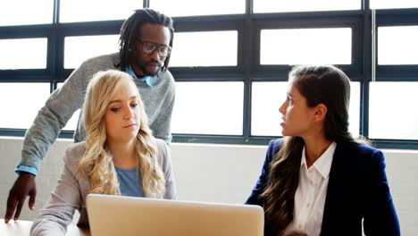 male and female business executives discussing over a laptop