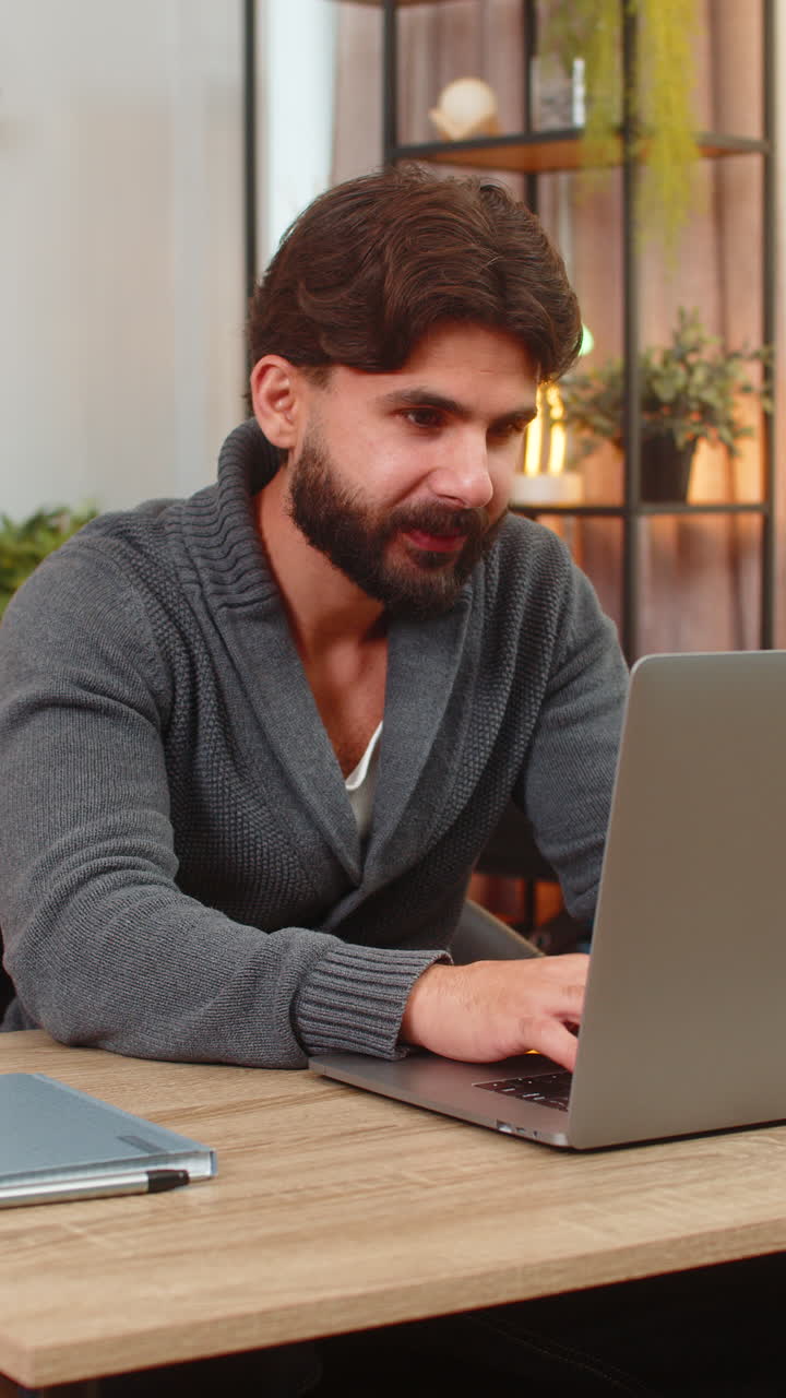 Indian man hits submit on laptop gets project approval smiles fist pump celebrates victory good news