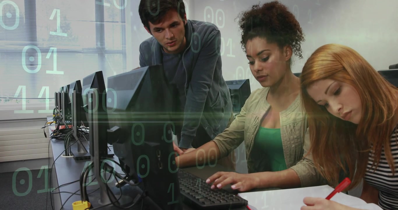 Man leaning over desk guiding user typing right user noting binary overlaying screens in tech lab