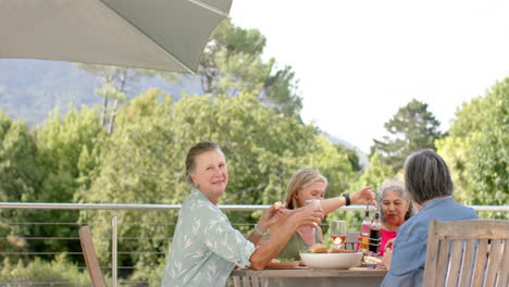 diverse group of women enjoy a meal outdoors, with copy space