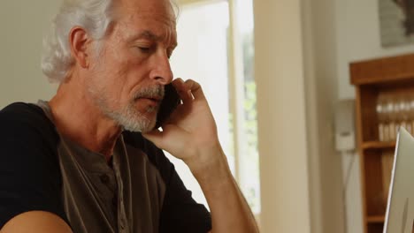 Senior-man-talking-on-mobile-phone-at-home-4k