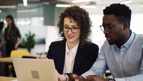 diverse colleagues collaborating on laptop