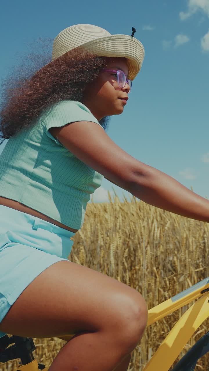 Ragazza in bicicletta in un campo di grano