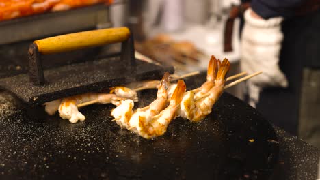 shrimp skewers being flame-grilled on a barbecue