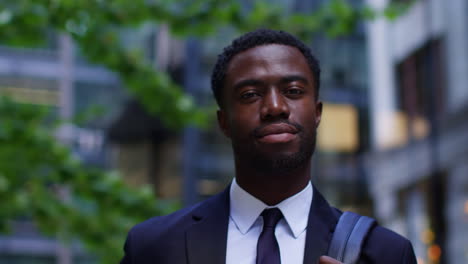 Portrait-Of-Confident-Young-Businessman-Wearing-Suit-Standing-Outside-Offices-In-The-Financial-District-Of-The-City-Of-London-UK-2