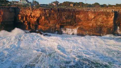 foamy sea water hitting dangerous coastal rocks drone view. stormy ocean waves