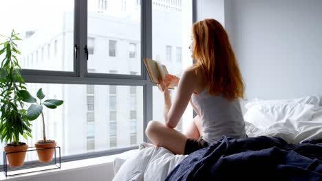 woman reading a book in bedroom at home 4k