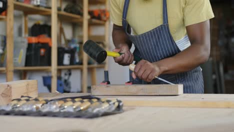 carpintero tallando madera con martillo en la mesa 4k