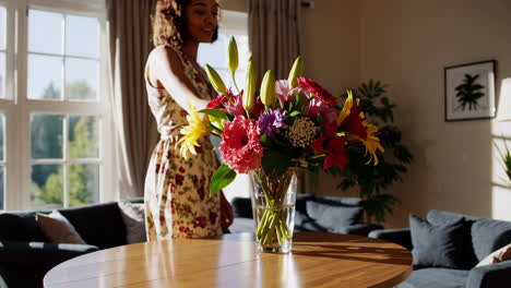 woman arranging flowers in living room