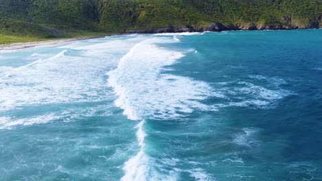 Stunning-coastline-of-Tayrona-National-Park,-with-waves-crashing-onto-the-shore,-aerial-view