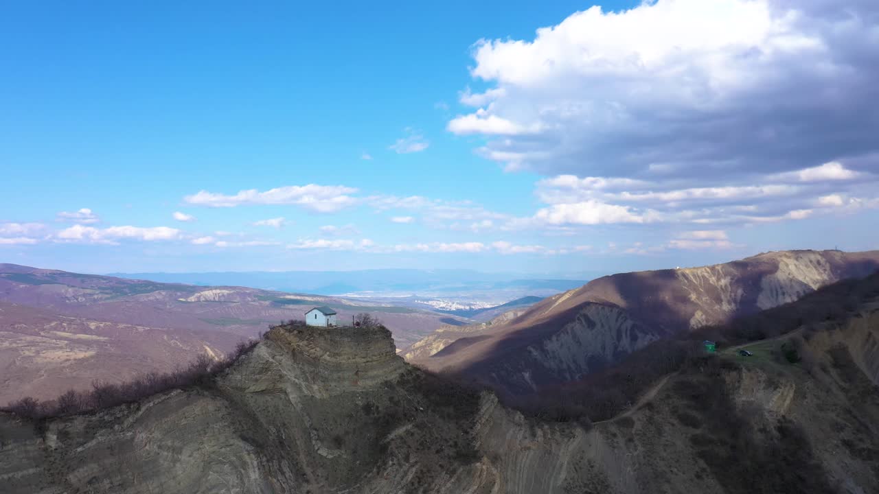 낮에 그루지야 산 풍경이 내려다보이는 산 꼭대기에 있는 츠베리 교회