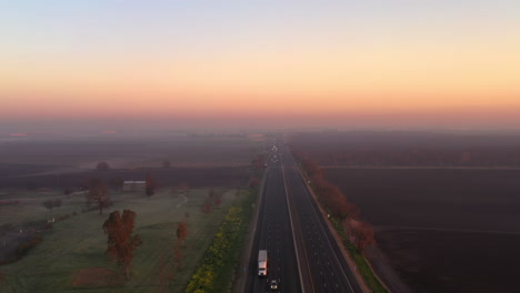 cars and trucks on highway 99 in the morning. big rig trucks and cars drive along the scenic highway running across the central valley in california landscape at sunrise
