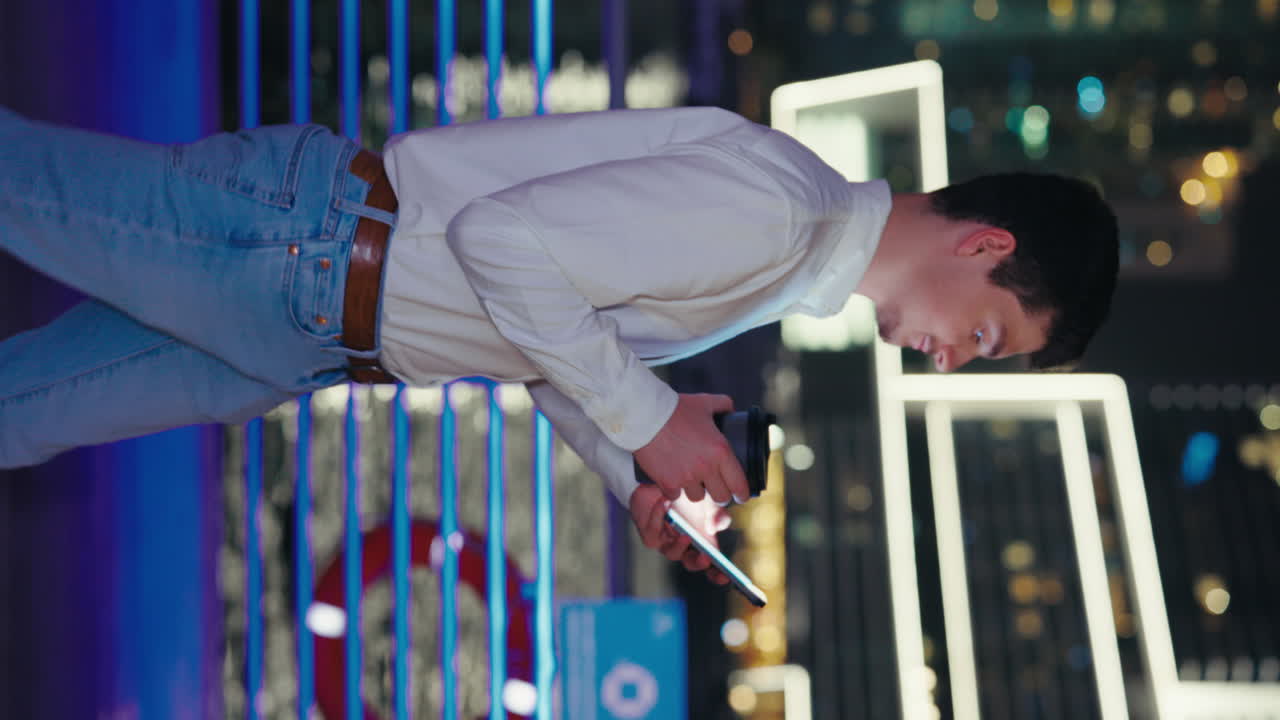 Man using smartphone at night in the city