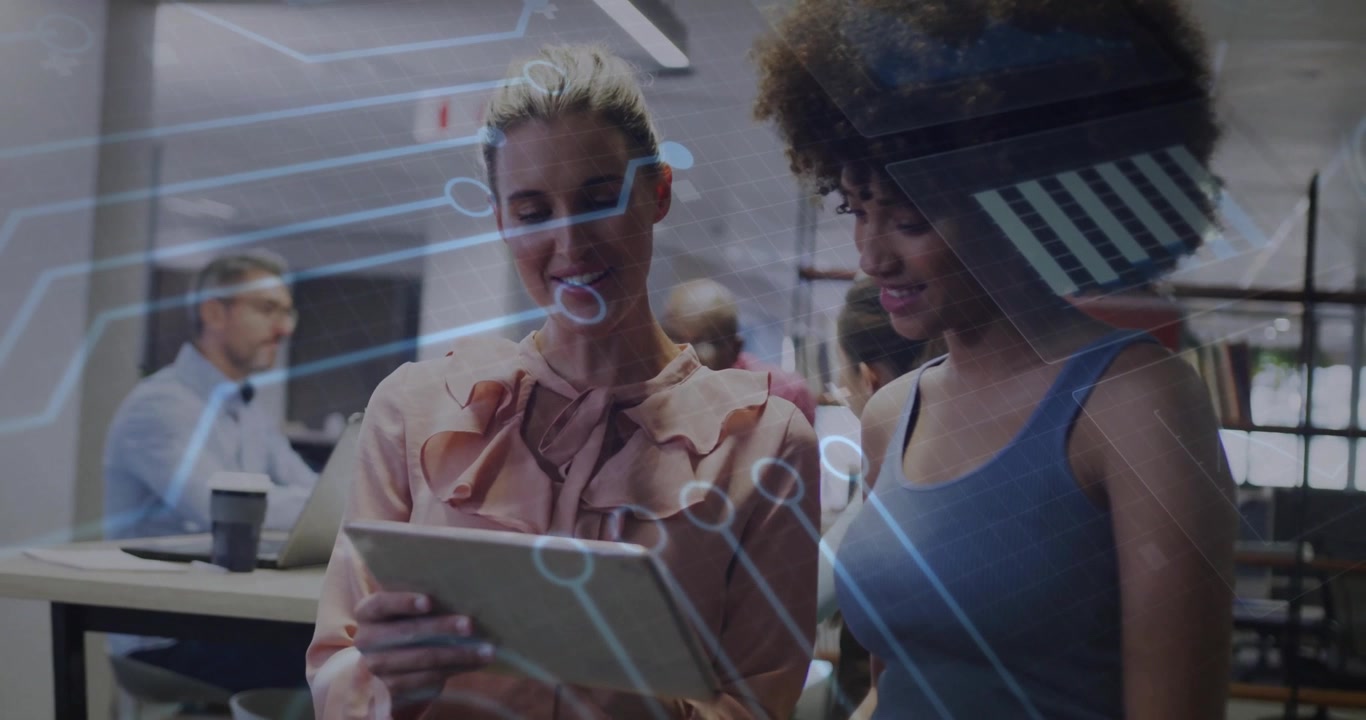 Woman swiping tablet and colleague tapping icon initiating blue circuit overlay for business review