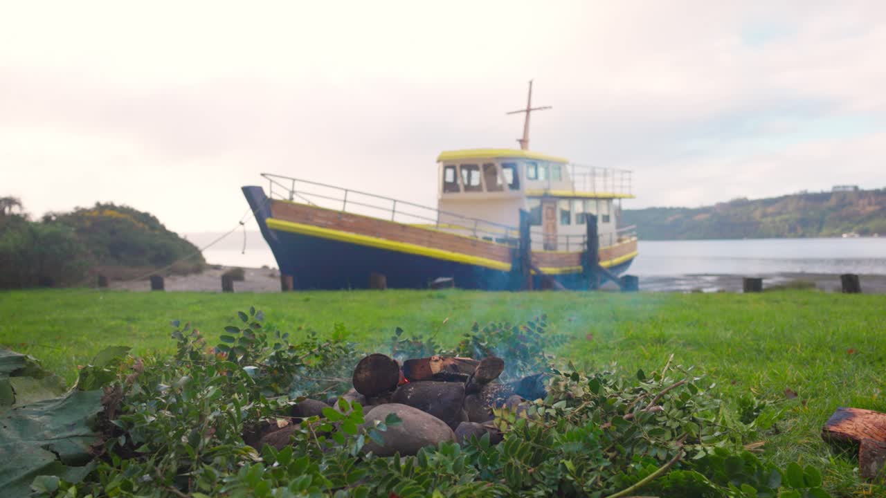 Curanto hole and boat in Castro, Chilo&eacute; south of Chile