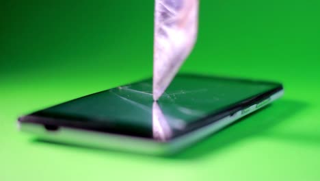 el cuchillo encaja en la pantalla táctil del smartphone con fondo verde