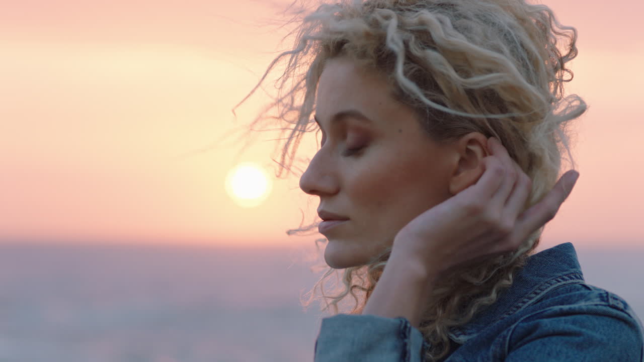 retrato de una hermosa mujer disfrutando de la tranquilidad de la playa al atardecer contemplando el viaje explorando la espiritualidad sintiendo la libertad con el viento soplando el cabello