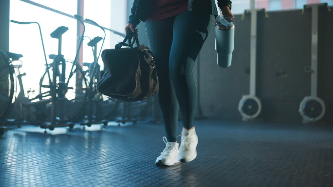Woman with gym bag and water bottle at the gym