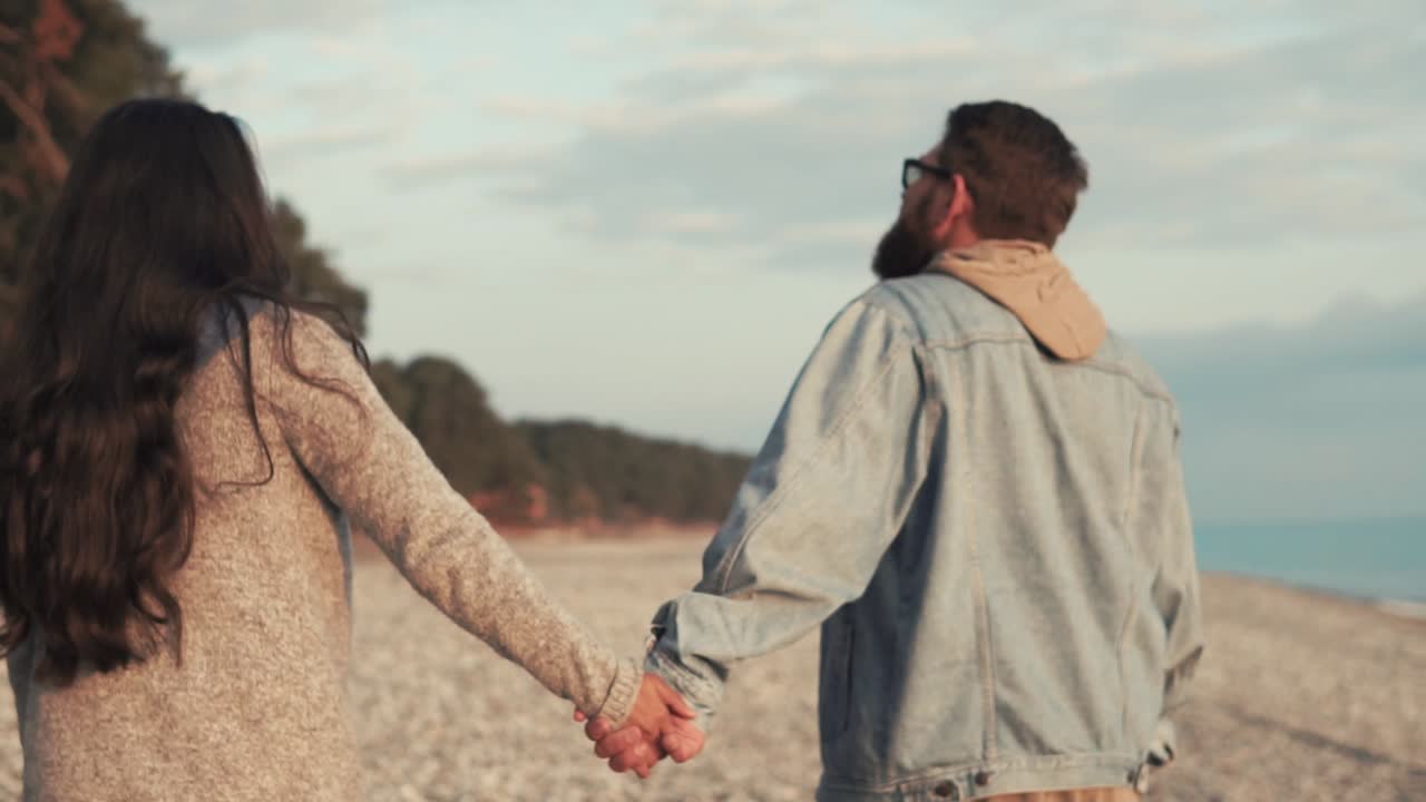 해가 지는 해변에서 손을 잡고 는 부부