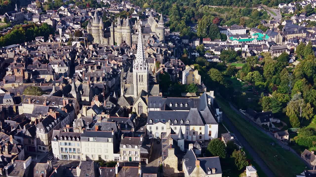Notre Dame Kirke i forgrunden og Château de Vitré i baggrunden i Bretagne, bybillede af Vitré, Bretagne i Frankrig. Luftfoto med drone sideværts
