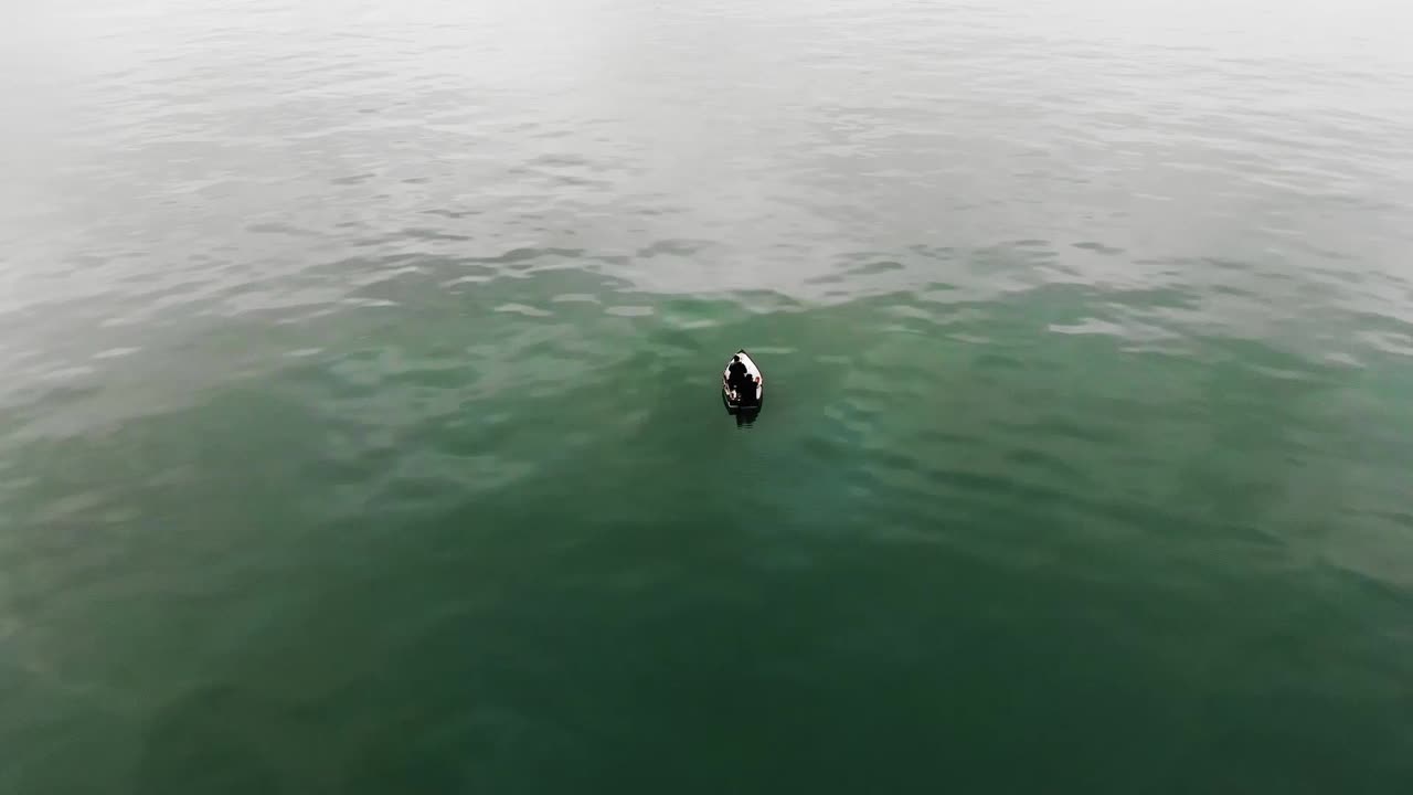 toma aérea en órbita de una pareja en lancha relajándose en el tranquilo océano atlántico durante el día soleado en brasil