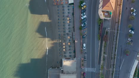 Top-down-drohnenaufnahme-Des-Strandes-Und-Der-Straße-Von-Laigueglia,-Ligurien-Während-Des-Sonnenuntergangs