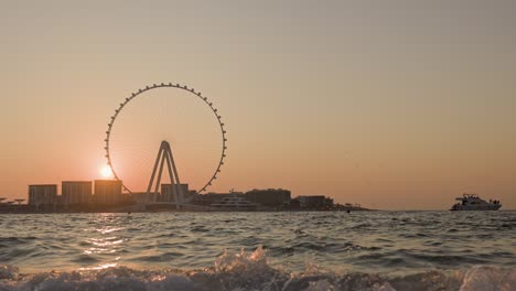 unsurpassed sunset over the biggest ferris wheel in dubai marina uae.