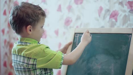 schoolboy painting on the blackboard