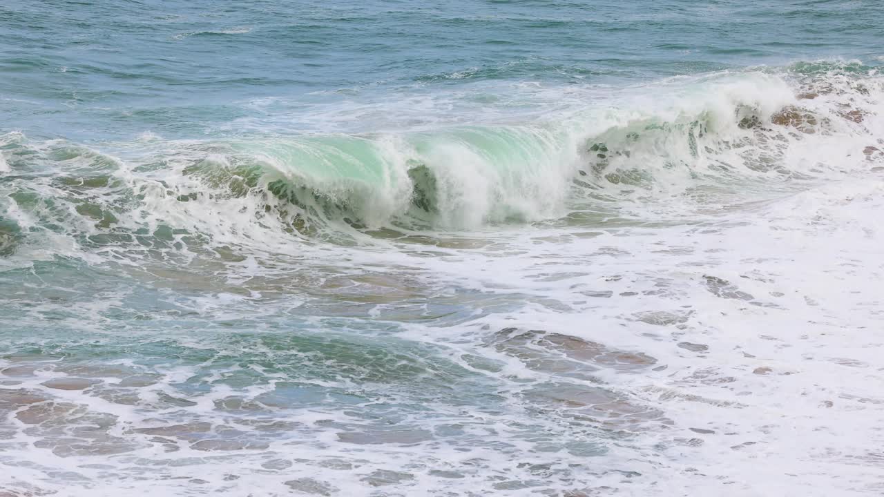 Dynamic waves crash against the rocky shore at Port Campbell, Australia, captured in natural daylight with a steady camera