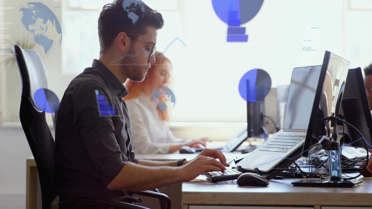Man sitting desk typing and mousing, causing blue charts over screens and showing business data
