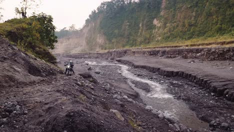 Adventure-motorcycle-rider-takes-loose-dirt-corner-up-mountain