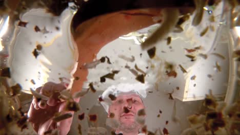 chef prepares vegetable broth. chef adds spice to the soup, the view from the pan in slow motion.