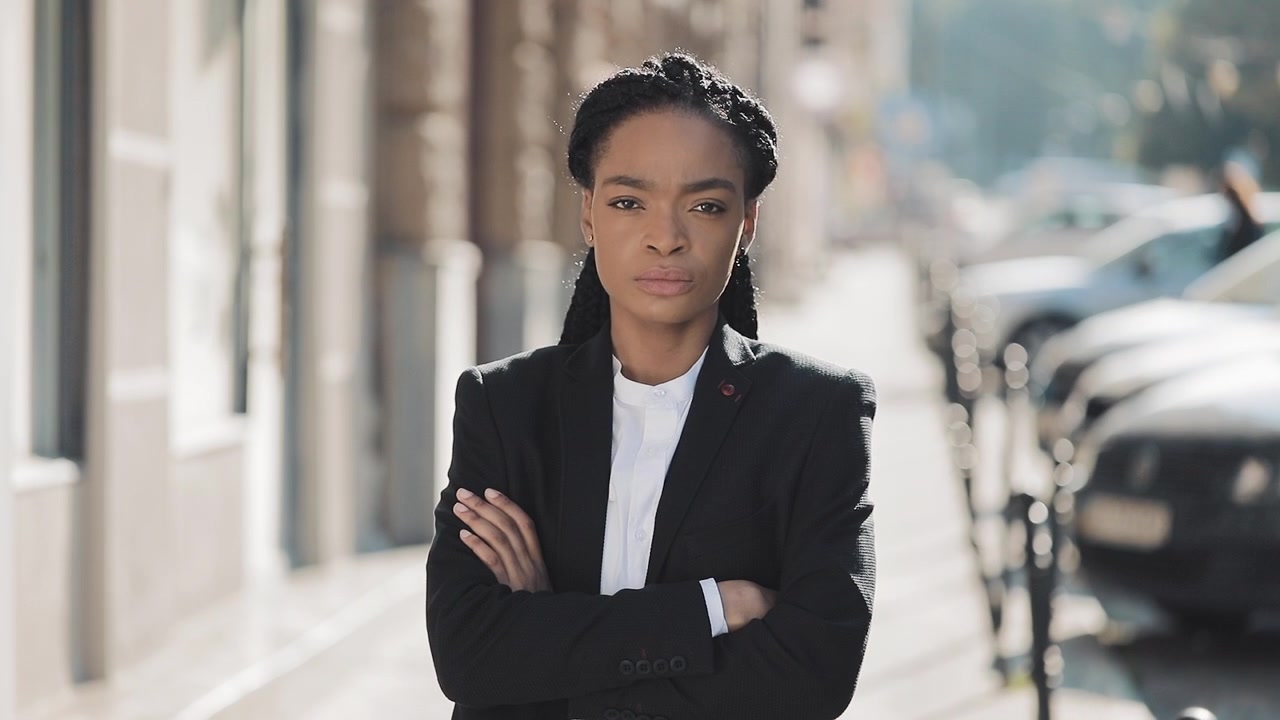 Confident Businesswoman Standing on City Street with Arms Crossed