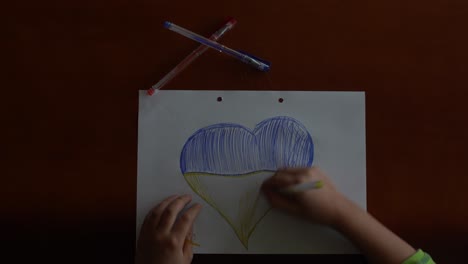 Ukrainian-flag-and-a-heart-in-yellow-and-blue-color.-Child-draws-a-heart-on-the-blackboard