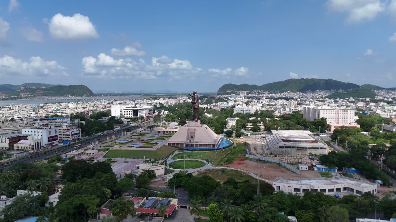 Aerial shot of Vijayawada city, showing densely packed buildings and urban scenery with statues of unity.