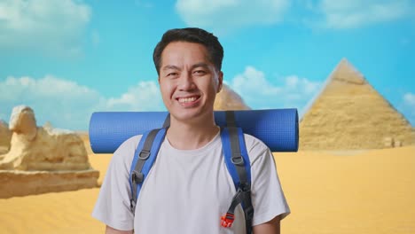 close up of asian male hiker with mountaineering backpack smiling to camera while traveling in pyramid of giza