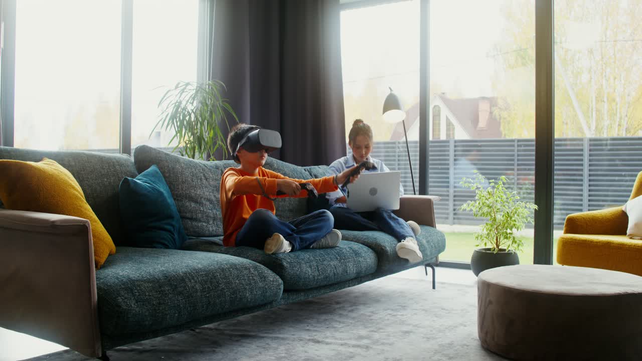 Children playing VR games and using laptop in living room