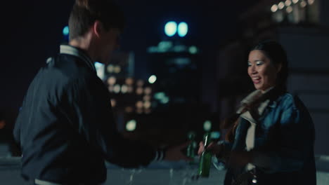 happy friends dancing on rooftop at night having fun enjoying playful dance celebrating weekend