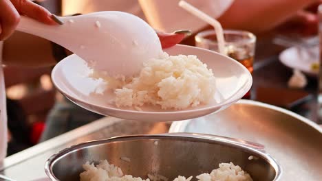 scooping rice onto a plate at a gathering