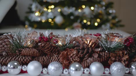 Weihnachtsdekoration-Aus-Tannenzapfen-Für-Teelichter,-Umgeben-Von-Einer-Girlande-Aus-Silbernen-Kugeln