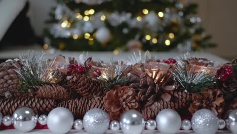 christmas decoration made of fir cones for tea lights surrounded by a garland of silver balls