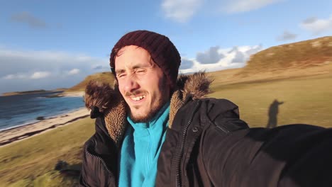 happy adventurer spinning around green meadow, ocean at the background, highlands, scotland, clear sky, traveling shot