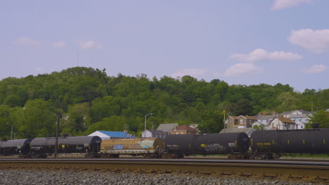 a train engine backs up to reveal rows of tanker cars on the adjacent train tracks in the rust belt